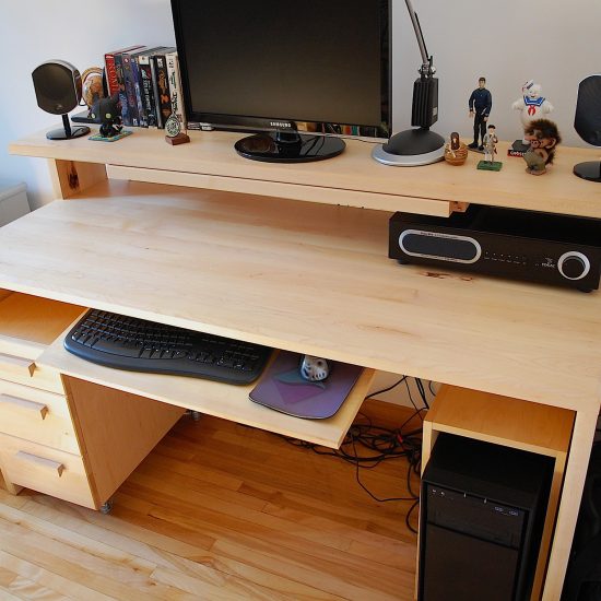 Bureau multimédia comportant des tiroirs, un espace pour la tour d'ordinateur et des tablettes pour écran et clavier